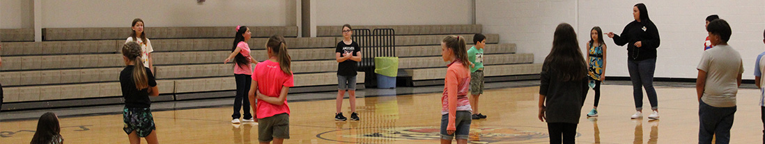 students in the gym with a staff member